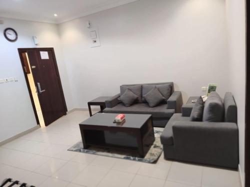 a living room with a couch and a coffee table at شاطئ البندقية للشقق المخدومة in Hafr Al Baten