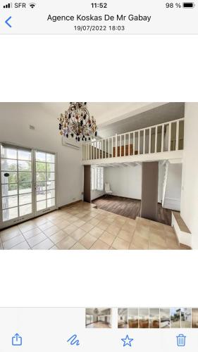 Cette grande chambre comprend un lustre et un escalier. dans l'établissement villa matama, à Cannes
