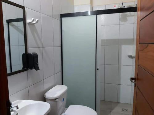 a bathroom with a toilet and a sink and a shower at Hotel Oasis in Riberalta