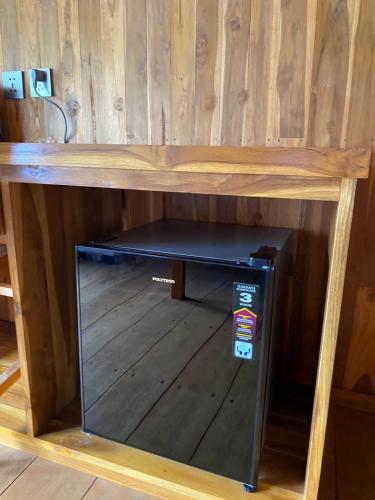a wooden table with a shelf in a room at The Alam Bungalow & Restaurant in Tetebatu
