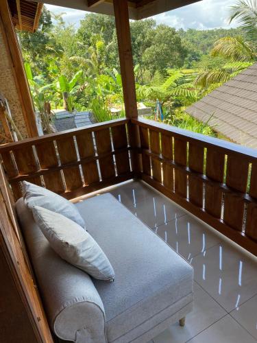 a bench on the porch of a house at The Alam Bungalow & Restaurant in Tetebatu