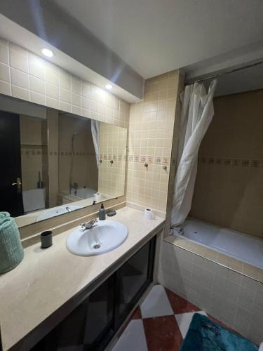 MARINA Agadir flat في أغادير: حمام مع حوض و مرآة و حوض استحمام