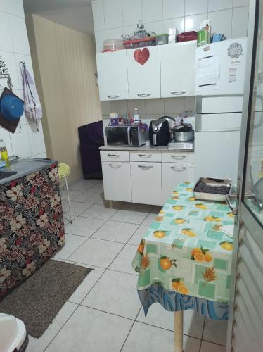 巴西利亚Quarto em casa de Família- Riacho的厨房里有一张铺着桌布的桌子
