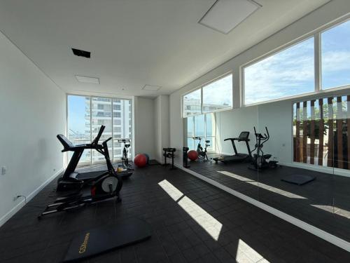 a gym with treadmills and ellipticals in a room with windows at Edificio Eira in Santa Marta