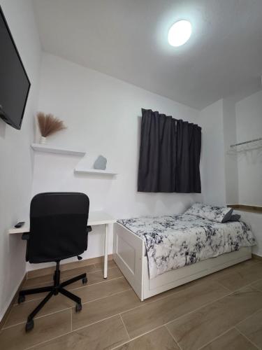 a bedroom with a bed and a desk and a chair at Villa Narok in Tarajalejo