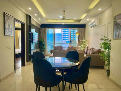 Una sala de estar con una mesa y sillas y un sofá. en Sky Heights Luxury Apartments Facing Centaurus Mall Islamabad, en Islamabad