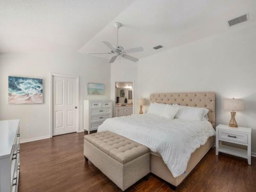 Un dormitorio blanco con una cama y un ventilador de techo. en 2537 Z3b VILLAGE OF HADLEY by REMAX Premier, en The Villages