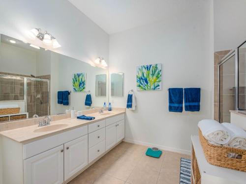 Un baño con dos lavabos y un espejo grande. en 2537 Z3b VILLAGE OF HADLEY by REMAX Premier, en The Villages
