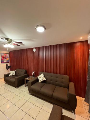 a living room with two couches and a red wall at House in Alta Vista Complex in San Martín