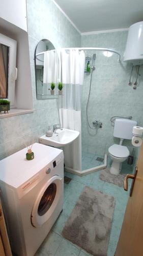 a bathroom with a washing machine and a sink at Apartmani Tarik in Mostar