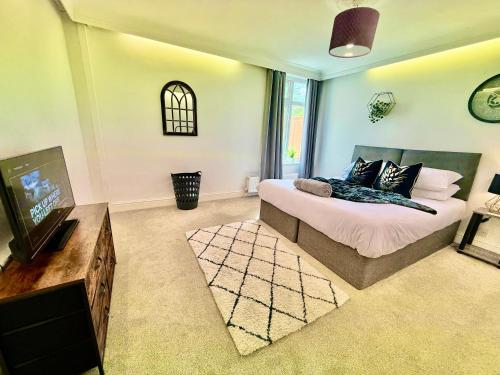 a bedroom with a bed and a flat screen tv at 6 bedroom house - Pool table - Contractors - Crew in Colchester