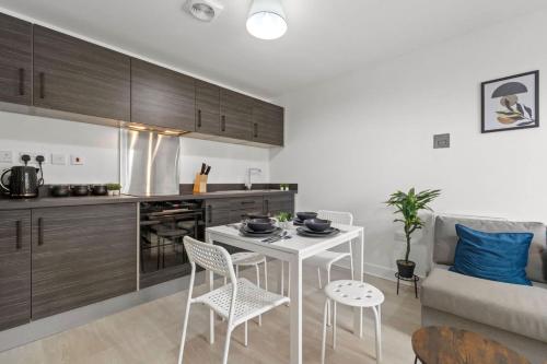 a kitchen and living room with a table and chairs at Modern 2-Bed House 10-min to Leeds City Centre in Leeds