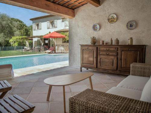 un salon avec une table et une piscine dans l'établissement Alcalias, à Valbonne