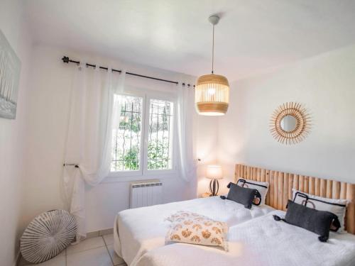 une chambre avec deux lits et une fenêtre dans l'établissement Les Myrtes, à Saint-Tropez