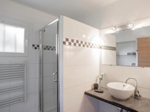 une salle de bain blanche avec un lavabo et une douche dans l'établissement Les Myrtes, à Saint-Tropez