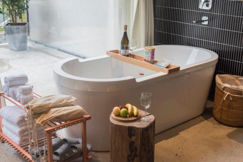 a bath tub with a bottle of wine and a bowl of fruit at Shanyu Life Huangshan Design Hotel in Huangshan