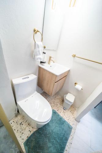 a bathroom with a white toilet and a sink at Room 6 Affordable Cool in Santurce Arts Area in San Juan