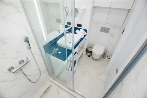 a bathroom with a shower and a sink and a toilet at Batumi black sea view central Hotel in Batumi