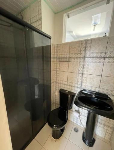 a bathroom with a black toilet and a shower at Ap COP 30 in Ananindeua