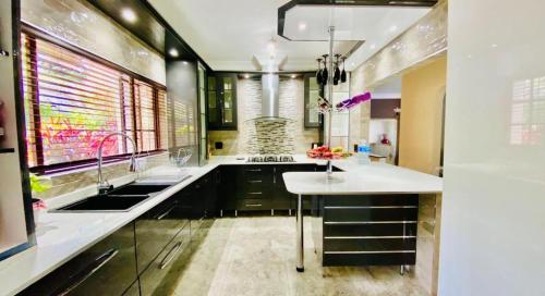Una cocina con gabinetes negros y una encimera blanca. en Al-Pat, en Vosburg