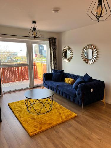 a living room with a blue couch and a table at Lakeside Apartment - 2 Bed, Free Parking in West Thurrock