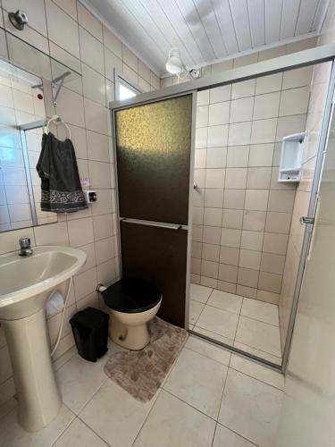 a bathroom with a toilet and a sink and a shower at Pé na Areia Piúma in Piúma