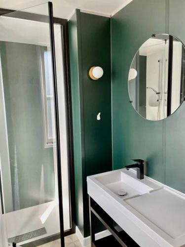 une salle de bain avec un lavabo et un miroir dans l'établissement Camping 3 étoiles - Piscine - efb0gh, à Erquy