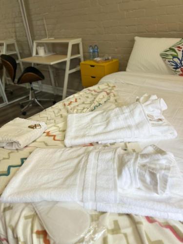 a bed with white sheets and towels on it at Downtown Private Room Central Location in Toronto