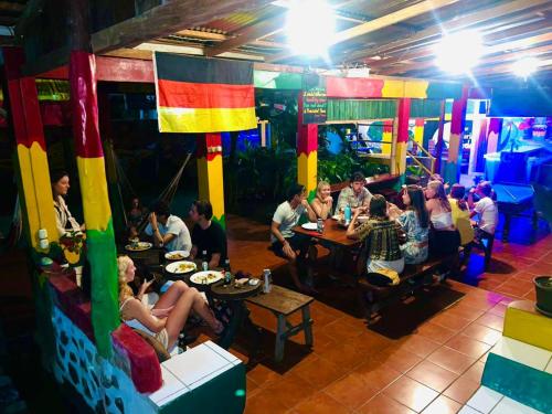 a group of people sitting at tables in a restaurant at Lazy Crab Hostel in Balgue