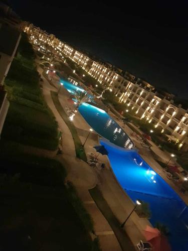 a large blue airplane sitting on a runway at night at Lasirina palm beach for families only in Ain Sokhna