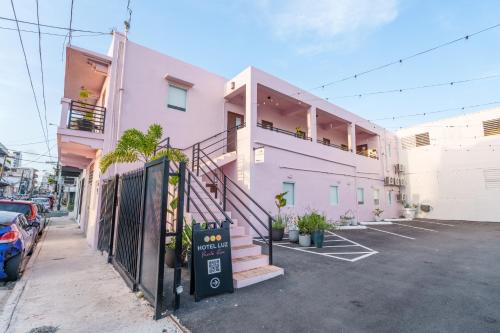 a pink building with a staircase in a parking lot at Room 8 Colorful Crash Pad Near Cerra Art in San Juan