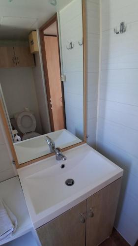 a bathroom with a sink and a mirror at Cute House Marinho in Santa Maria da Feira