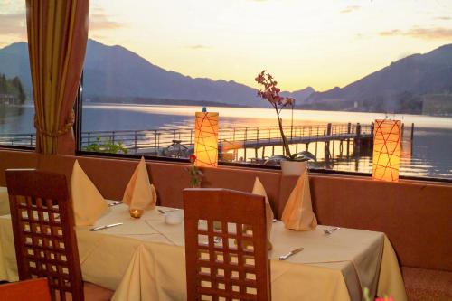 a restaurant with two tables and a view of the water at Seehotel Lilly in Strobl