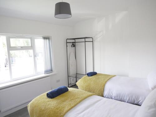 a bedroom with two beds with yellow blankets at Three bed house in Wolverhampton in Bushbury