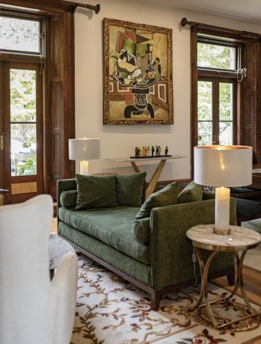 a living room with a green couch and a table at Islington Hotel in Hobart