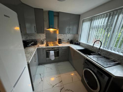 a kitchen with a sink and a stove top oven at Three bed house in Wolverhampton in Bushbury