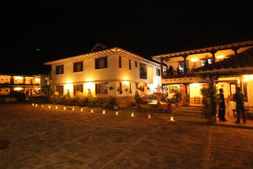 a large white building with lights in front of it at night at Hotel Santa Viviana Villa de Leyva in Villa de Leyva