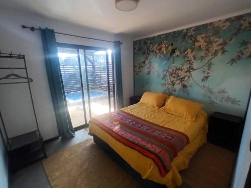 a bedroom with a bed with a painting on the wall at SirenaHouse, Casa a metros del Mar in De Cauquenes