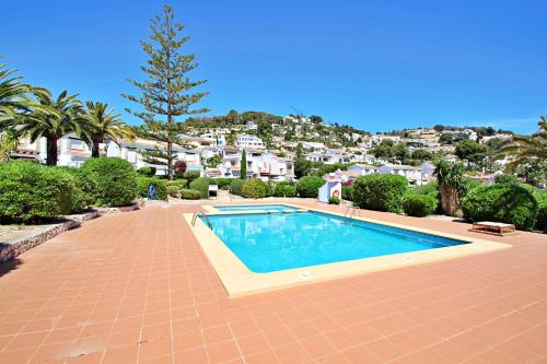 una piscina en una pasarela de ladrillo junto a una casa en Beate - holiday bungalow with pool in Moraira, en Moraira