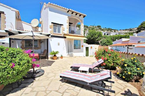 un patio con 2 tumbonas y una casa en Beate - holiday bungalow with pool in Moraira, en Moraira