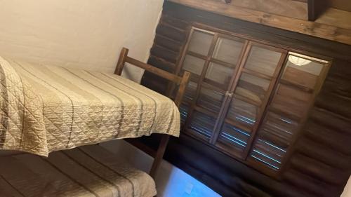 a bedroom with a bed and a wooden cabinet at Los leños de Iporá in Balneario Ipora