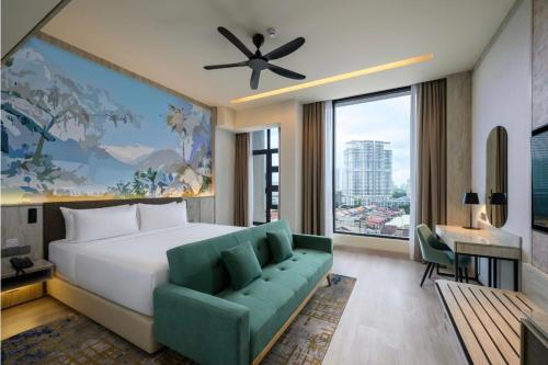 a bedroom with a large bed and a green couch at Fifth Avenue Hotel in George Town