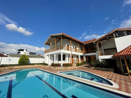 a swimming pool in front of a house at Refugio de Paz Casa en Anapoima in Anapoima