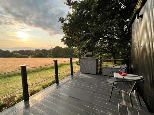 a wooden deck with two chairs and a table at Molly Top Farm in Marsham