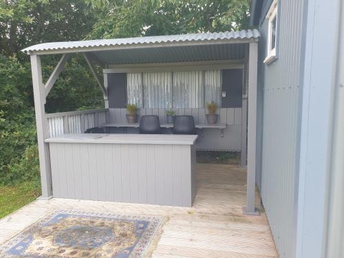 a white pergola with two chairs on a patio at Florence Top Farm in Marsham