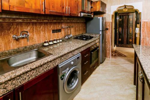 a kitchen with a sink and a washing machine at The Rina Hostel in Agadir