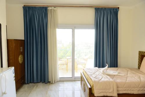 a bedroom with a bed and a sliding glass door at Flamingo Boutique hotels in Luxor