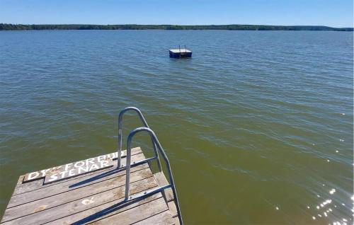 a wooden pier with a boat in the water at 1 Bedroom Cozy Home In Eskilstuna in Eskilstuna