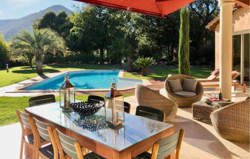 un patio avec une table et des chaises et une piscine dans l'établissement Wunderschönes Haus In Saint-Jean-De-Lestere, à Les Adrets-de-Fréjus