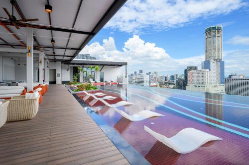 a rooftop patio with white chairs and a view of the city at Fifth Avenue Hotel in George Town